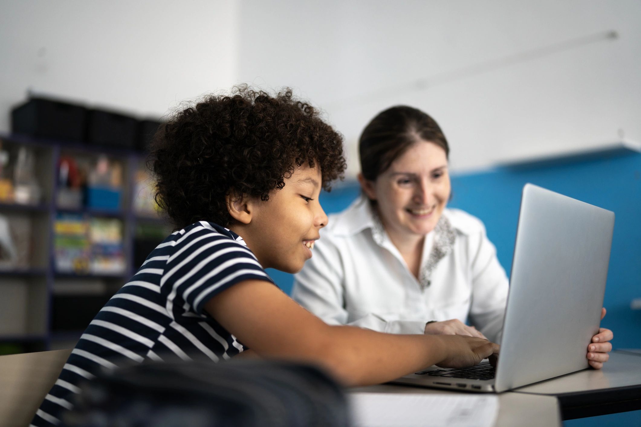 Teacher and student learning together with a laptop