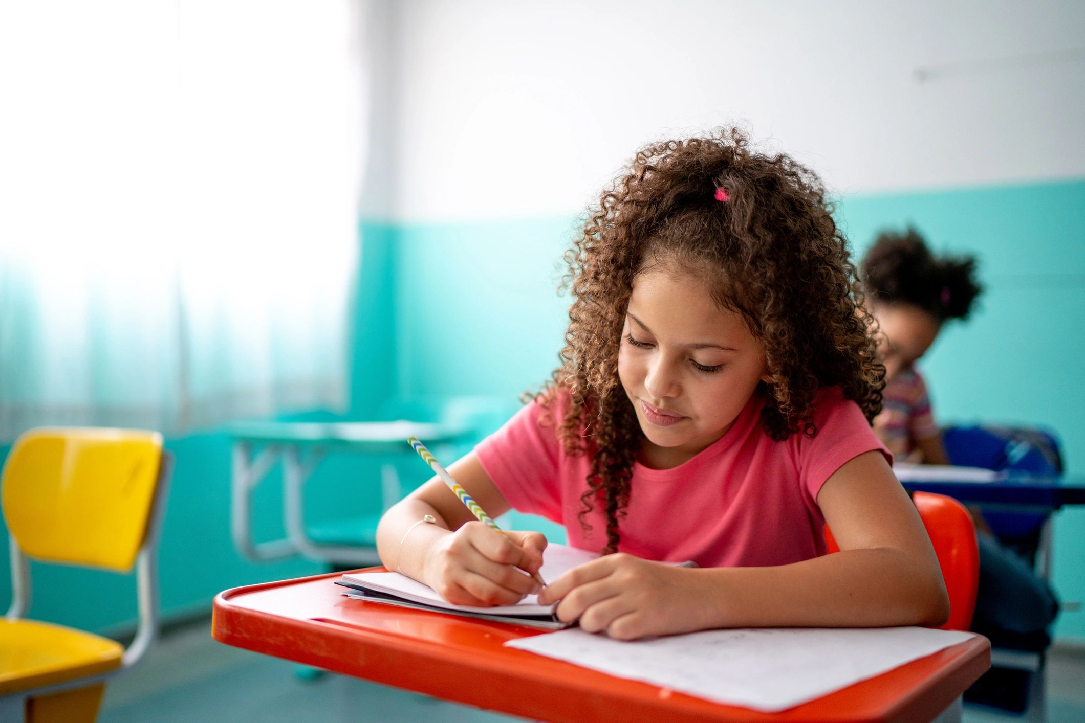 Student taking notes while working at a desk