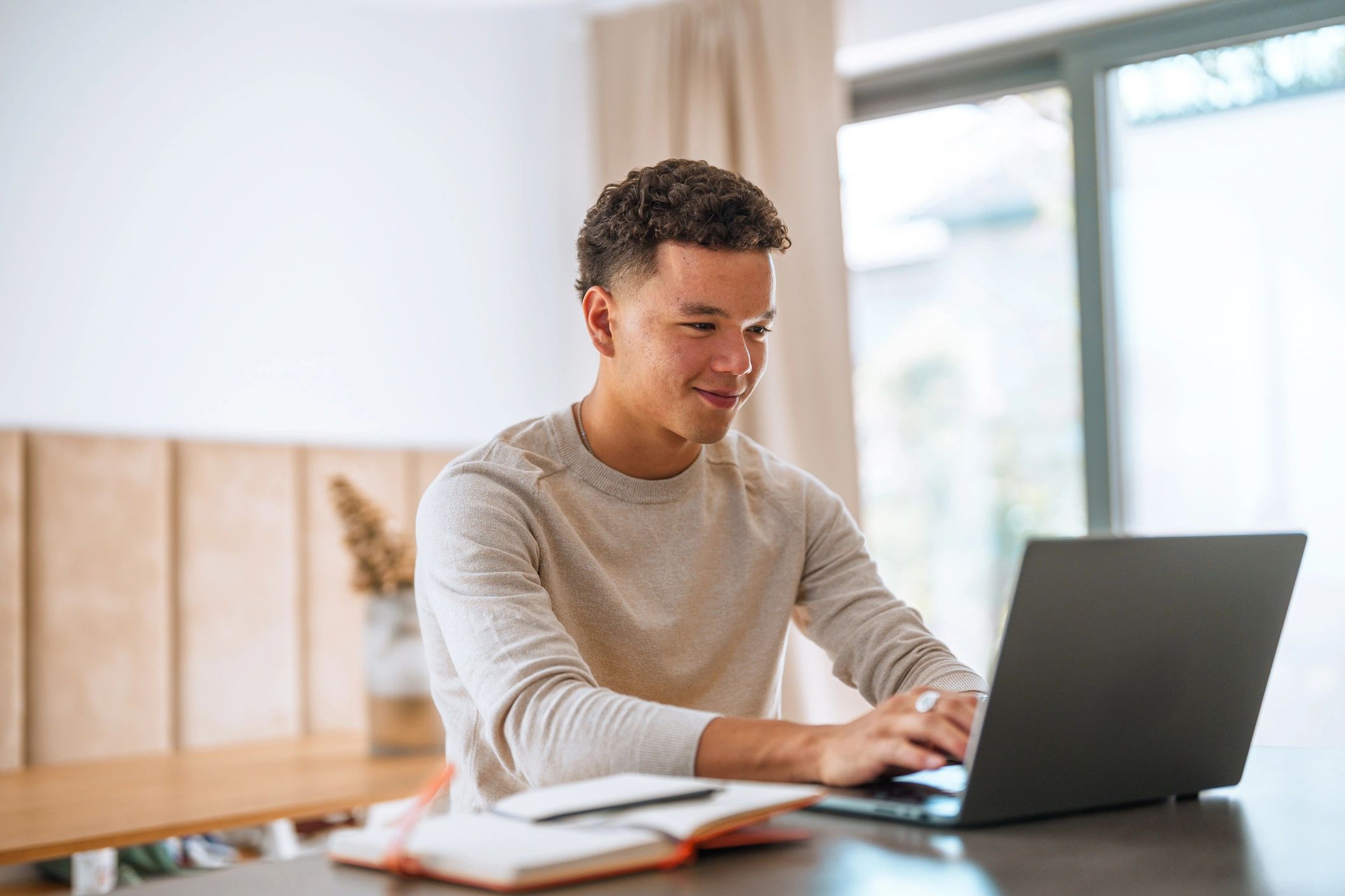 Student studying with a laptop and textbooks at home