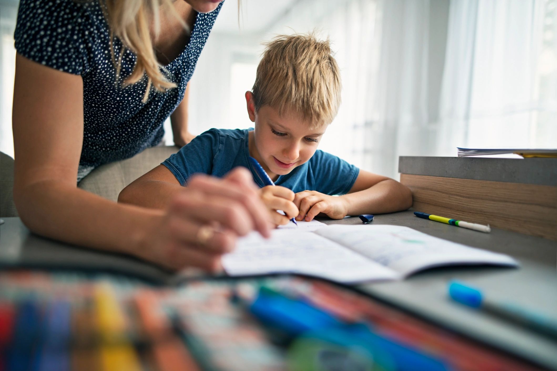 Parent helping a child with homework at the table